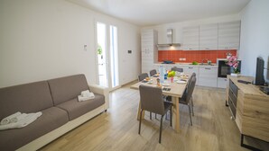Un salon moderne avec un canapé et un coin repas comprenant une table et des chaises.