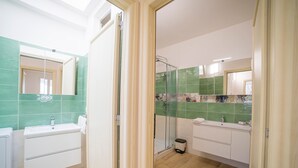 Une salle de bain moderne avec une douche à parois de verre, un lavabo blanc et un meuble-lavabo avec un miroir.