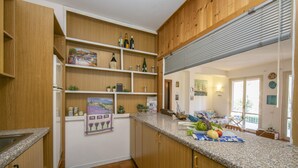 A kitchen with wooden cabinets, a granite countertop, and various kitchen items. - Casa Lavanda Pool Tennis (Ispra)
