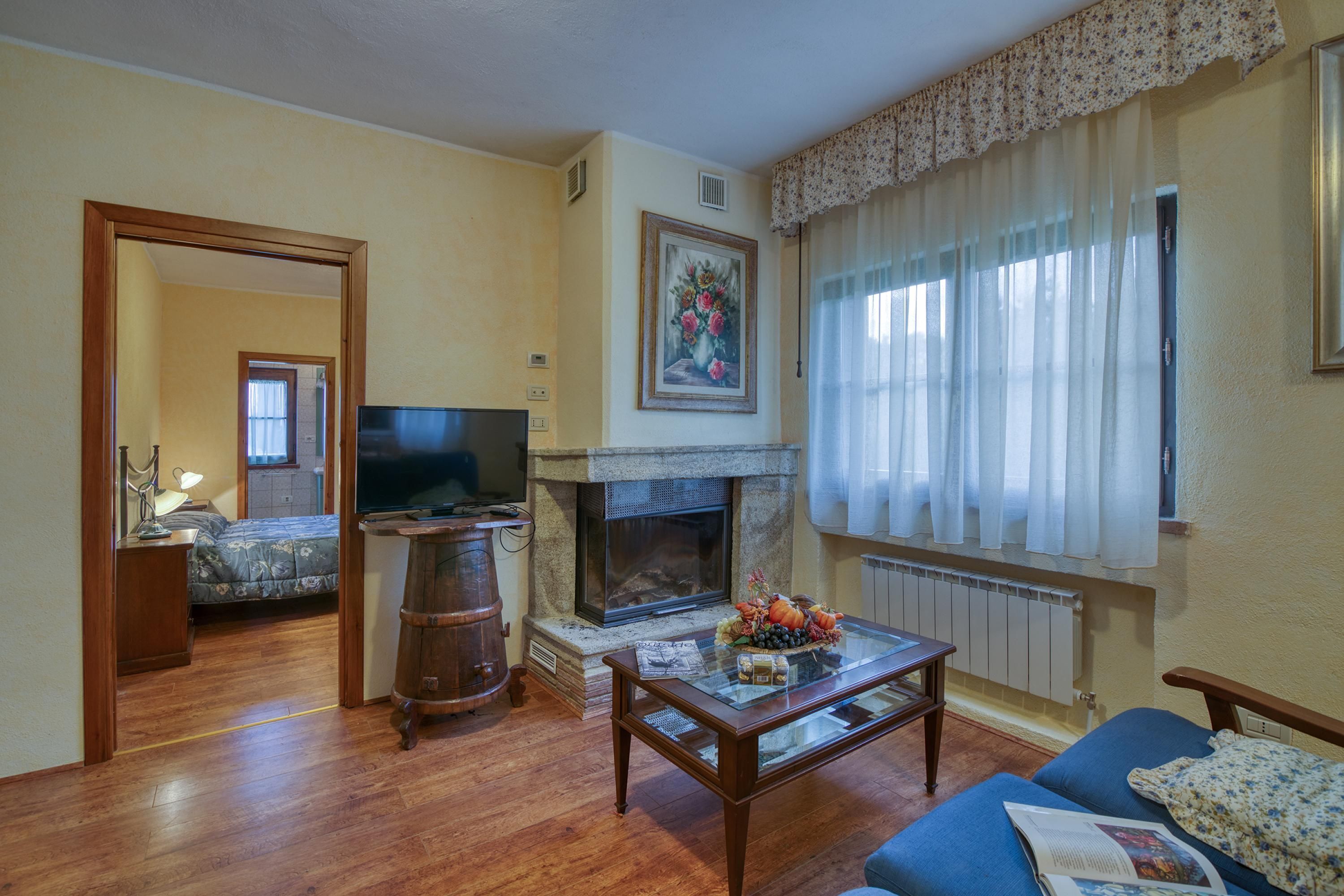 A living room with a fireplace, a television, a sofa, and a coffee table.