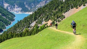 Un sentier de VTT offrant une vue sur un lac et des montagnes boisées.