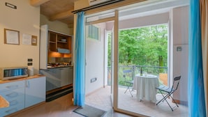 A modern kitchen with a microwave, cabinets, and a dining area with a table and chairs.
