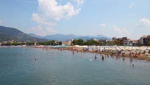 Une plage avec des parasols et des gens qui se baignent.