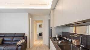Une cuisine moderne dotée d’un plan de travail foncé, d’appareils électroménagers en acier inoxydable et d’un grand évier.