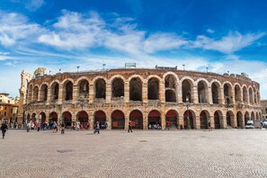 Un bâtiment historique doté de nombreuses arcades et d’une vaste place publique qui s’étend devant lui.