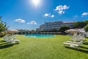A pool area with lounge chairs and umbrellas, surrounded by a well-maintained lawn. - Feel So Good in Bunthe (Olbia)