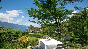 Une table dressée à l’extérieur, avec vue sur les montagnes et un lac.