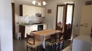 Una cocina compacta con una mesa de comedor, sillas y un refrigerador.