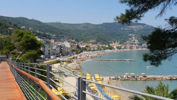 A coastal town with a wooden boardwalk, beach with umbrellas, and a view of the sea and hills. - Gabri By The Sea in Diano Marina (Diano Marina)