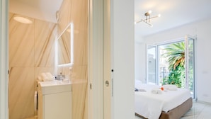 Un baño moderno con tocador de madera y zona de ducha.