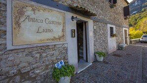Un edificio in pietra con un cartello che riporta la scritta "Antica Casina Liano".