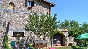 A stone building with a wooden playhouse, outdoor seating, and a barbecue area. - Mimosa in Hilly Area (Gargnano)