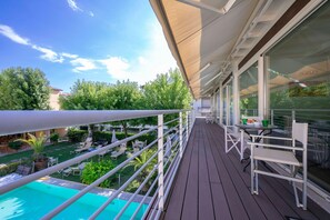 A balcony with a pool, outdoor seating, and a view of the greenery below. - Il Bacco few Steps From sea (Camaiore)