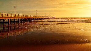 A pier extending into the ocean with a sunset in the background. - Il Bacco few Steps From sea (Camaiore)