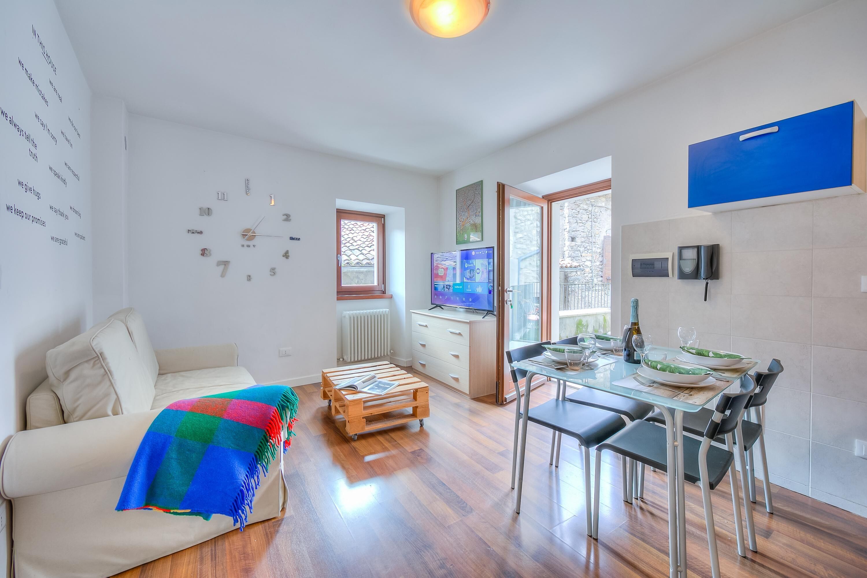 Un salon moderne comprenant un canapé, une table basse en bois, un téléviseur et un coin repas avec des chaises et une table.