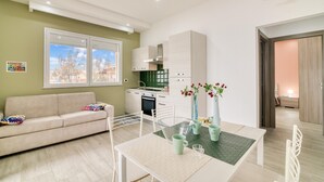 Eine moderne Wohnung mit Essbereich, Küchenzeile und einer Couch.
