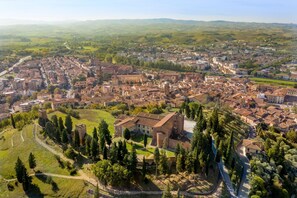 An aerial view of a historic town with a prominent church, narrow streets, and surrounding greenery. - Maramaldo Morellino Shared Pool Chianti (Castelfiorentino)