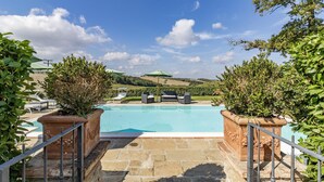 A swimming pool with stone steps leading up to it, surrounded by greenery and a clear sky. - Maramaldo Morellino Shared Pool Chianti (Castelfiorentino)
