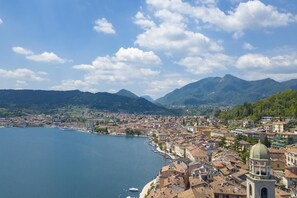 A coastal town with a prominent church and a clear view of the lake and mountains in the background. - Casa Mirabella With Lake View (Salò)