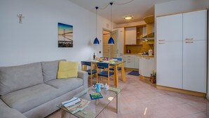 Ein modernes Wohnzimmer mit Sofa, Couchtisch und Essbereich.