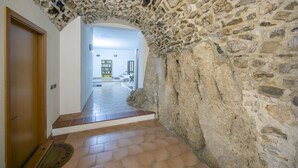 Un couloir avec une arche en pierre menant à un espace bibliothèque.