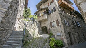 Un escalier étroit en pierre mène à un immeuble doté de nombreux balcons et fenêtres.