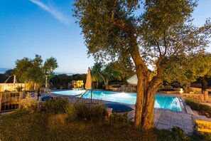 Relax by the serene pool surrounded by lush greenery and mature trees.
