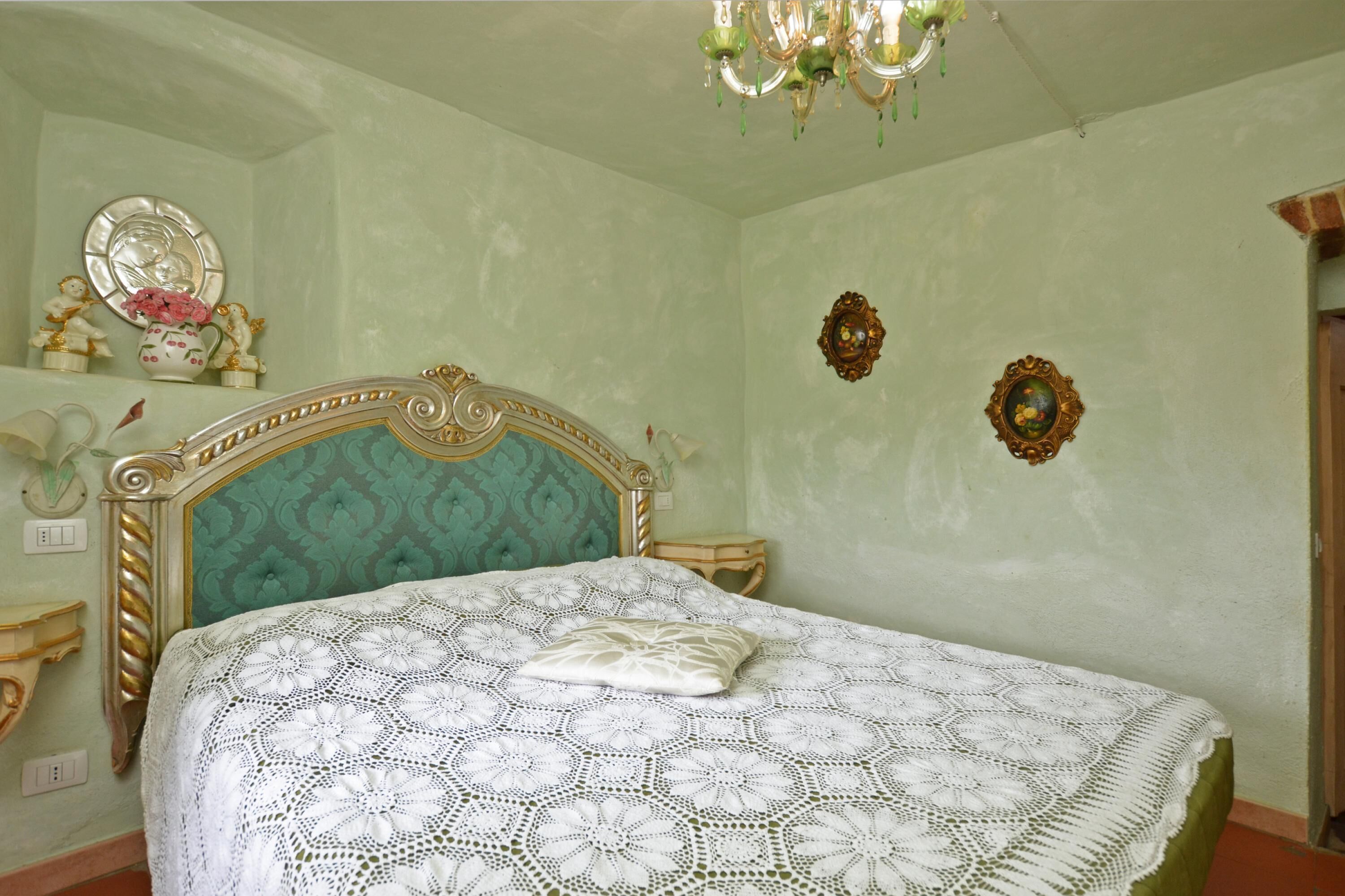 Une chambre à coucher avec un lit, un lustre et des éléments décoratifs sur les murs.