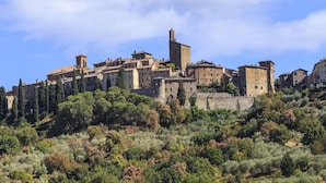 Uma cidade histórica com arquitetura medieval, incluindo torres e muralhas fortificadas.