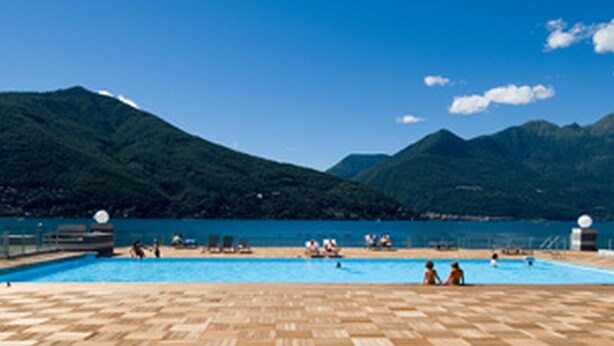 A pool area with a view of mountains and a clear sky.
