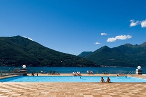 A pool area with a view of mountains and a clear sky. - Vista di Maccagno Fantastico Pool (Maccagno con Pino e Veddasca)