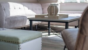 En moderne stue med sofa, sofabord og et vindue med udsigt.