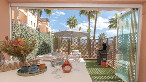 A patio with a table set for dining, outdoor furniture, and a grill. - Family Duplex Riviera With Pool (Mijas)