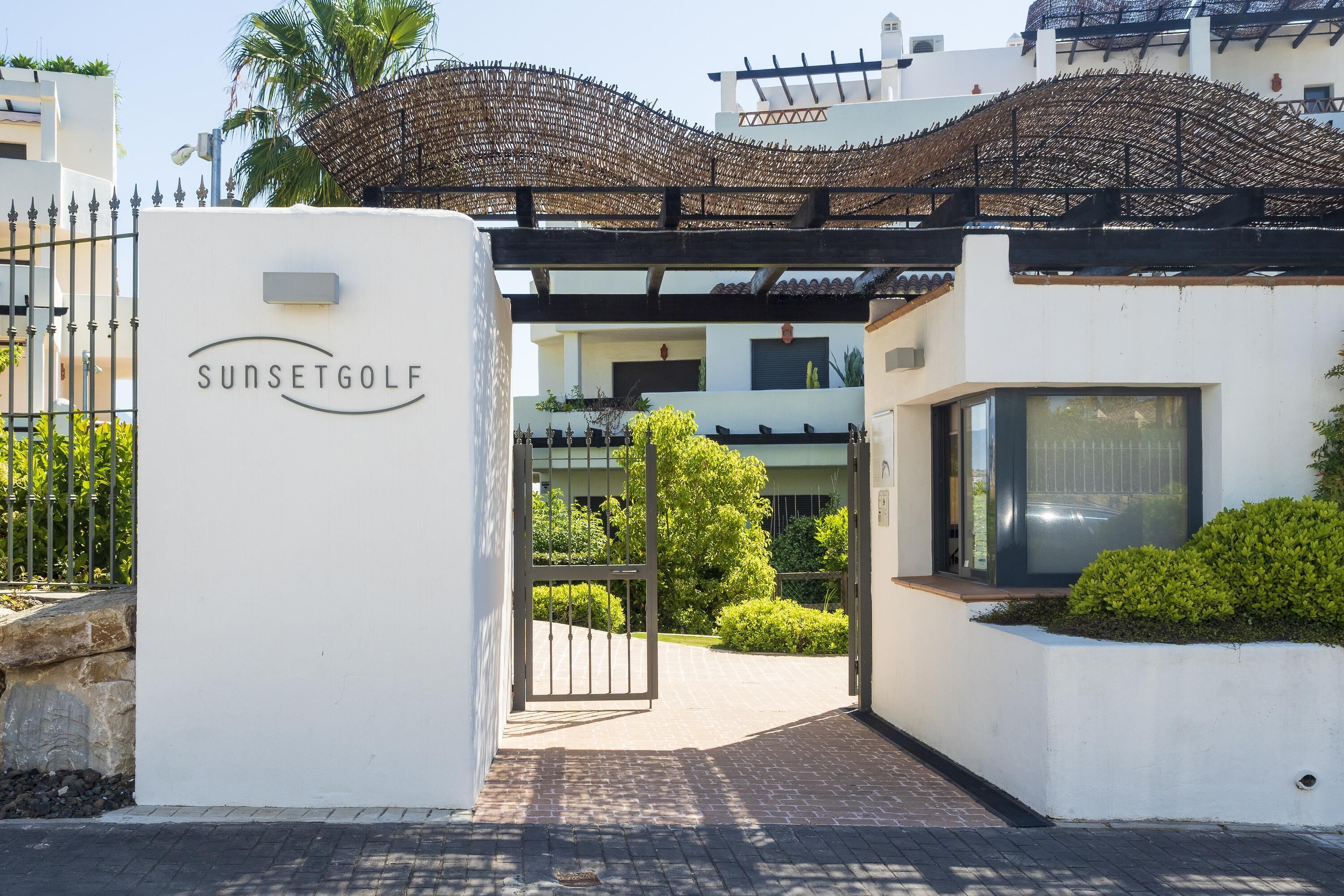 A gated entrance to SunsetGolf with a clear pathway leading to the building.