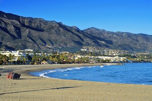 A coastal town with a beach, mountains, and residential buildings. - Sunset Golf Groundfloor Shared Pool (Estepona)