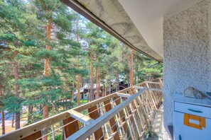 A view from a balcony with a wooden railing overlooking a forested area. - La Tana Dello Scoiattolo Skiing Nearby (Bardonecchia)