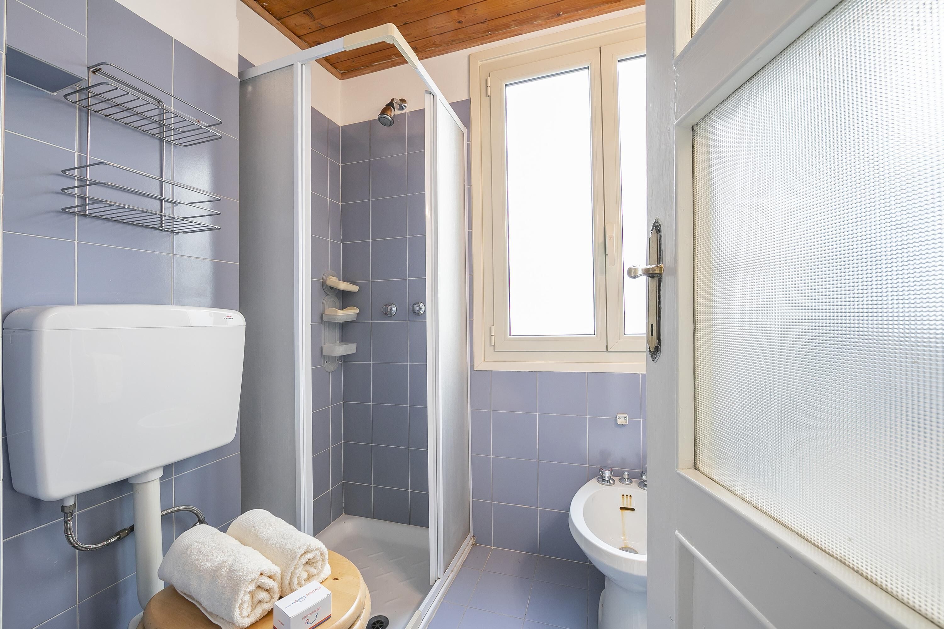 A bathroom with a toilet, a shower, and a sink.