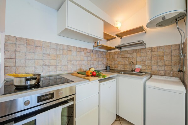 A modern kitchen with a stove, oven, dishwasher, and sink.