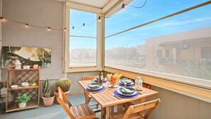 A dining area with a table set for four, a cactus, and a potted plant on a shelf. - Monopoli Beach House (Monopoli)