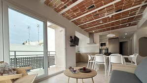 A modern living room with a balcony, a kitchen, and a dining area. - Arago 273 in Roses With 2 Bedrooms and 2 Bathrooms (Roses)