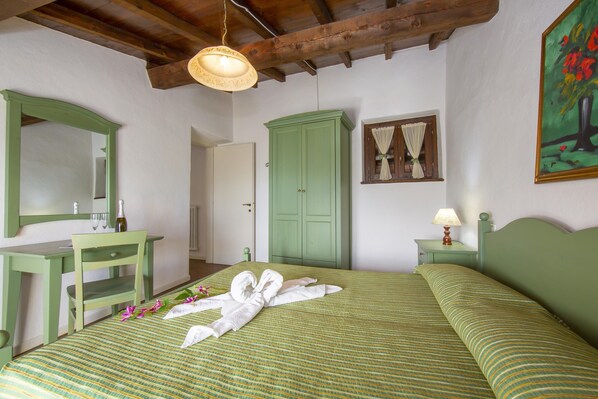 A room with a bed, a green desk, a mirror, a wardrobe, and a painting on the wall. - Violetta in Hilly Area (Gargnano)