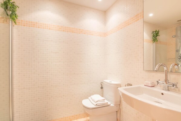 A bathroom with a toilet, sink, and shower. - Sunset Golf International (Estepona)