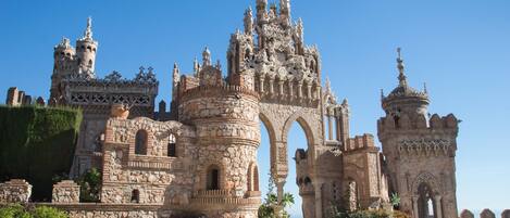 A historic building with intricate stone architecture, featuring multiple towers and arches.