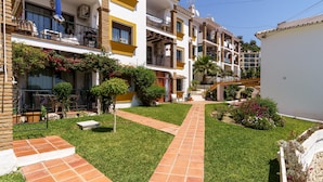 A residential building with multiple balconies, a well-maintained garden, and a clear pathway. - Sunny Tranquility With Pool (Benalmádena)