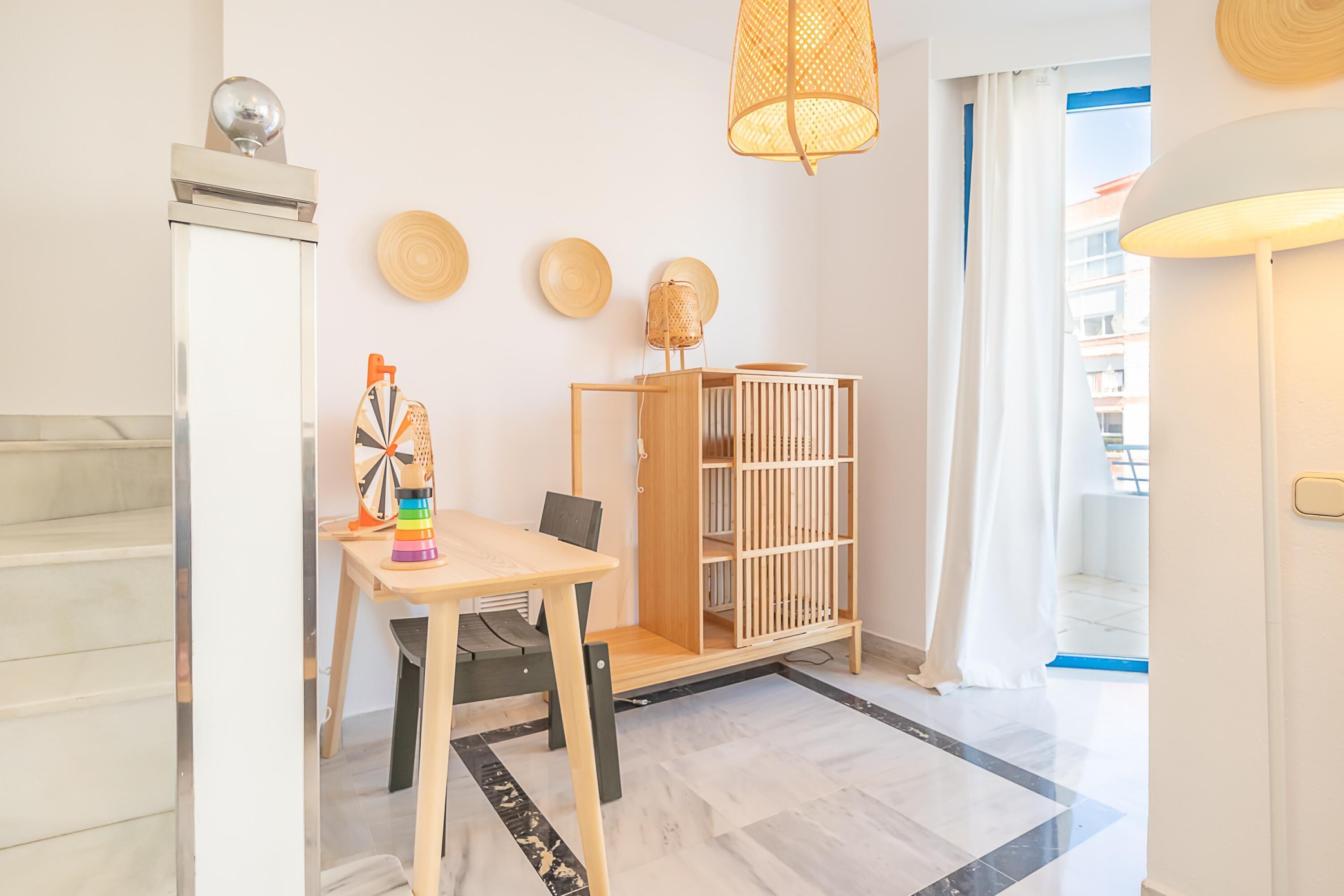 Een moderne, goed verlichte kamer met een houten tafel, stoelen, een boekenkast en een decoratieve wand.