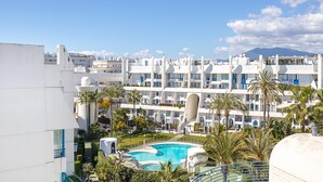A hotel with multiple balconies, a swimming pool, and a mountainous backdrop. - Marbella Pool House Ph77 on sea Shore (Marbella)