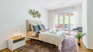 A modern bedroom with a bed, bedside table, and a view of the outdoors. - Duplex Marbella Concordia Close To Beach (Marbella)