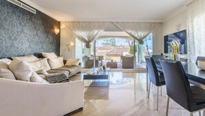 A modern living room with a sofa, coffee table, and dining area. - Hacienda Playa Beach And Pool (Marbella)