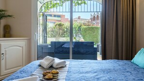Ein Hotelzimmer mit Bett, Blick nach draußen und einem Balkon mit Stuhl.