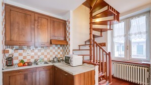 Una cucina con mobili in legno, un forno a microonde e un piano cottura.